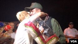 Luz Adriana Chalarca hugs a Venezuelan border guard after giving him a baby Jesus figure as a sign of peace. She organized a prayer vigil on a bridge linking Cúcuta, Colombia, and northwest Venezuela, July 30, 2017. (C. Mendoza/VOA Spanish Service)