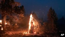 In this photo provided by the Bootleg Fire Incident Command, the Bootleg Fire burns at night near Highway 34 in southern Oregon, July 15, 2021.