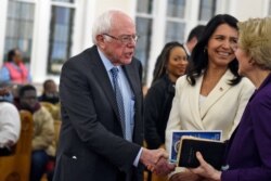 Democratic presidential candidates US. Sen. Bernie Sanders, left, I-Vt. and Sen. Elizabeth Warren, right, D-Mass., shake hands as U.S. Rep. Tulsi Gabbard, center, D-Hawaii, watches at a Martin Luther King Jr. Day services at Zion Baptist Church,…