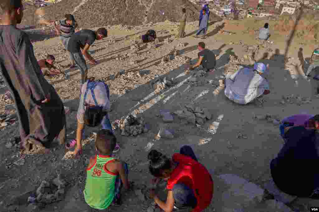 Pilgrims collect stones from the mountain to build a pyramid shape installation to cast on it their wishes. (H. Elrasam/VOA)