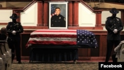 រូបថត​លោក​ ជីមមី អ៊ីន​ (Jimmy Inn) ត្រូវ​បាន​គេ​ដាក់​នៅ​ពី​លើ​មឈូស​របស់​លោក​នៅ​ឯ​ពិធី​បុណ្យ​សពរៀបចំ​ដោយ​​ស្នងការដ្ឋាន​​ប៉ូលិស​ក្រុង Stockton នៅ​​ព្រះវិហារ Christian Life Center នៅ​ក្រុង Stockton រដ្ឋ California កាល​ពី​ថ្ងៃ​ទី​១៩ ខែ​ឧសភា។ (Facebook/Stockton Police Department) 