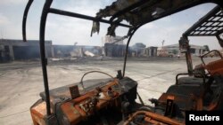 FILE - Damaged vehicles are left on the tarmac of Jinnah International Airport, after Sunday's attack by Taliban militants, in Karachi, June 10, 2014. 