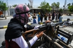 A Taliban fighter mans a machine gun on top of a vehicle as members of the insurgent group patrol along a street in Kabul, Aug. 16, 2021.