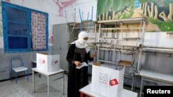 A voter casts a ballot at a polling station during a referendum on a new constitution in Tunisia, July 25, 2022. 