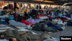 Qochqin va migrantlar supermarketning avtomobillar turadigan joyida uxlashmoqda