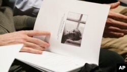 Mourners hold programs with the image of Matthew Shepard during a "Thanksgiving and Remembrance of Matthew Shepard" service at Washington National Cathedral in Washington, Oct. 26, 2018. The ashes of Matthew Shepard, whose brutal murder in the 1990s became a rallying cry for the gay rights movement, will be laid to rest in Washington National Cathedral.