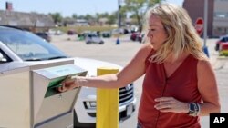 រូបឯកសារ៖ ស្ត្រីម្នាក់បានទម្លាក់សន្លឹកឆ្នោតរបស់ខ្លួនចូលក្នុងធុងបោះឆ្នោតតាមប្រៃសណីយ៍ នៅទីក្រុង Omaha រដ្ឋ Nebraska កាលពីថ្ងៃទី១៩ ខែសីហា ឆ្នាំ២០២០។