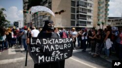 Une femme vêtue du 'costume du mort' tient une pancarte qui lit en espagnol: "La dictature de Maduro est la mort" lors d'un rassemblement à Caracas, Venezuela, le 27 avril 2017.