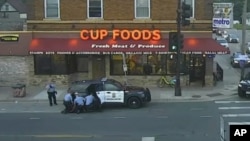 FILE - In this May 25, 2020, image from surveillance video, Minneapolis police officers, from left, Tou Thao, Derek Chauvin, J. Alexander Kueng and Thomas Lane are seen attempting to take George Floyd into custody in Minneapolis, Minnesota.