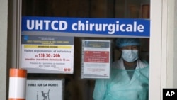 A medical staff looks through a door in an hospital in Rennes, western France, April 1, 2020..