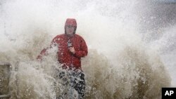 អ្នក​យក​ព័ត៌មាន​ម្នាក់​ឈរ​នៅ​ក្បែរ​ជញ្ជាំង​សមុទ្រ​នៅ​ក្នុង​ក្រុង Cedar Key ត្រូវ​បាន​រលក​បក់​លើ​ ខណៈ​ដែល​ខ្យល់​ព្យុះ Hurricane Hermine បោកបក់​លើ​ឆ្នេរ​សមុទ្រFlorida កាលពី​ថ្ងៃទី១ ខែកញ្ញា ឆ្នាំ២០១៦។