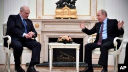 Russian President Vladimir Putin, right, gestures as he speaks to his Belarusian counterpart Alexander Lukashenko, foreground left, during their talks in the Kremlin in Moscow, Russia, Dec. 25, 2018.