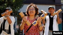 Elderly and middle-aged people exercise with wooden dumbbells during a health promotion event to mark Japan's "Respect for the Aged Day" at a temple in Tokyo's Sugamo district, September 18, 2017. REUTERS/Toru Hanai