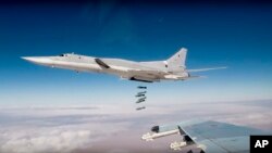 FILE - In this photo made from the footage taken from the Russian Defense Ministry official website on Nov. 26, 2017, Russian Tu-22M3 long-range bombers strike Islamic State targets in Syria.