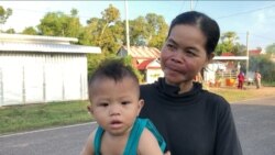 Sim Lat, 40, carries her nephew Ham Ya Oudom on a walk while waiting for his mom to come back from work, at Svay Ta Yean commune, Svay Rieng province, Cambodia, Oct. 11, 2019. (Khan Sokummono/VOA Khmer)