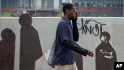 Un homme se couvre le nez et la bouche dans le centre-ville de Johannesbourg, Afrique du Sud, le 16 mars 2020.