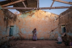A Tigray woman who fled the conflict in Ethiopia's Tigray region holds her child inside of her temporary shelter at Umm Rakouba refugee camp in Qadarif, eastern Sudan, Dec. 7, 2020.