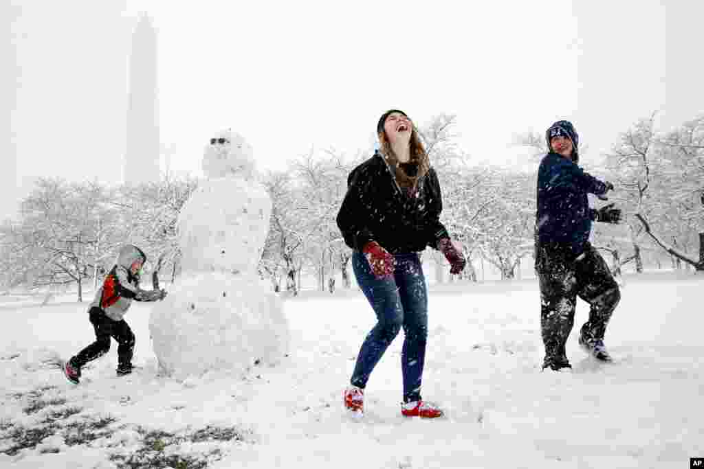 Des enfants s'amuse dans la neige à Washington, lors d'une tempête de neige, le 21 mars 2018.