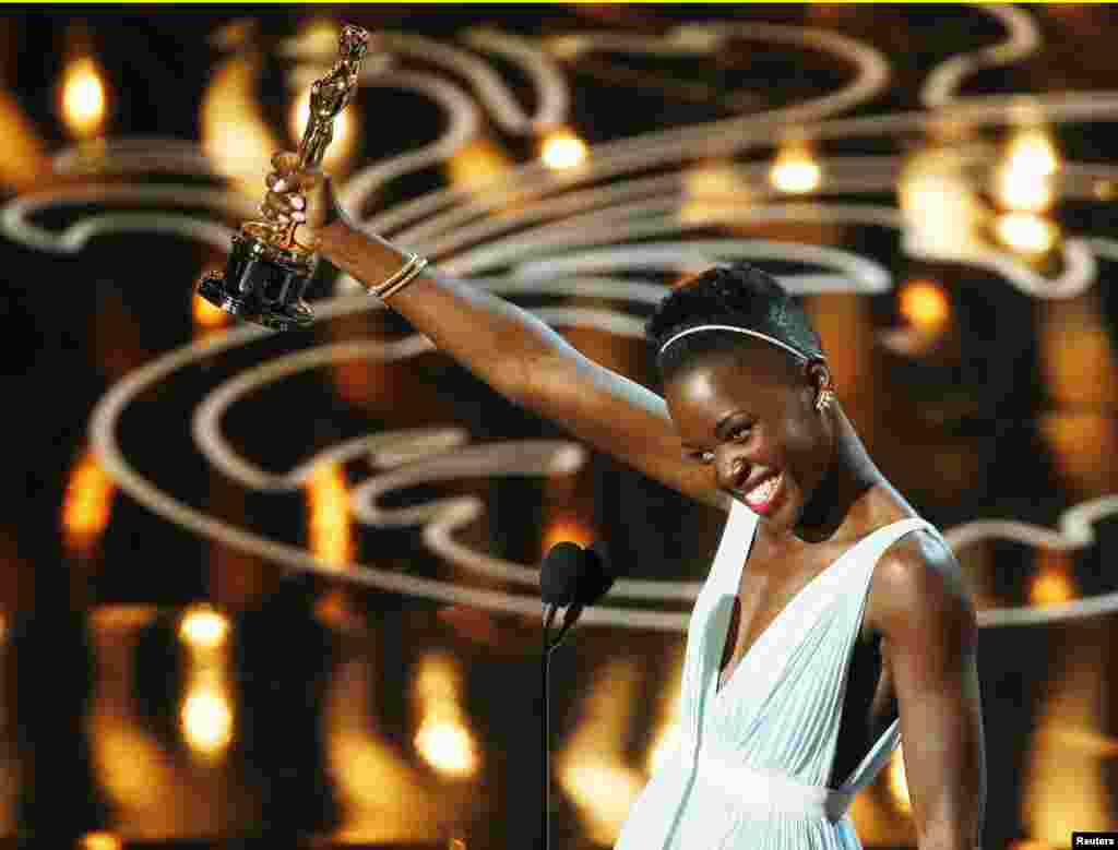 Lupita Nyong&#39;o, aktris pendukung terbaik untuk perannya dalam &quot;12 Years a Slave&quot;, menerima penghargaan di panggung Academy Awards ke-86 di Hollywood, California (2/3). (Reuters/Lucy Nicholson)