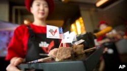 A hostess holds a tray of sliced American beef at an event to celebrate the re-introduction of American beef imports to China in Beijing, June 30, 2017. 