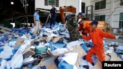 Rescue workers and soldiers search through a site of the accident in a shoe factory in the Kong Pisei district of Kampong Speu province, 50 km (30 miles) west of the capital, Phnom Penh, May 16, 2013.