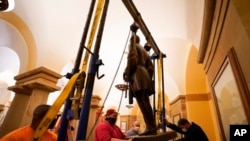 FILE - This Dec. 21, 2020 photo provided by the Office of the Governor of Virginia shows workers removing a statue of Confederate Gen. Robert E. Lee from the National Statuary Hall Collection in Washington.