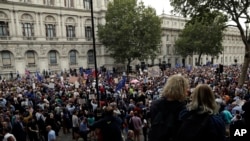 Anti-Brexit supporters gather outside the Prime Minister's residence 10 Downing Street in London, Wednesday, Aug. 28, 2019.