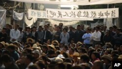 Residents of Wukan, a fishing village in the southern province of Guangdong, rally to demand the government take action over illegal land grabs and the death in custody of a local leader on December 15, 2011.