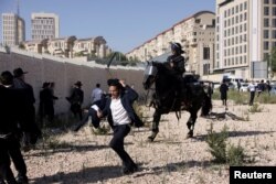 Arhiva - Policija na konjima rasteruje protesni skup ultraortodoksnih Jevreja koji se protive regrutaciji, ispred Vrhovnog suda Izraela, 2. juna 2024.