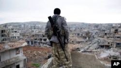 FILE - A Syrian Kurdish sniper looks at the rubble in the Syrian city of Ain al-Arab, also known as Kobani, Jan. 30, 2015.