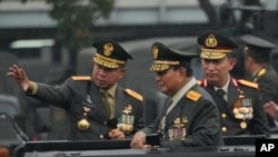 Menteri Pertahanan Prabowo Subianto (kanan) didampingi Panglima TNI Jenderal Agus Subiyanto (kiri) dan Kapolri Listyo Sigit Prabowo (kanan) memeriksa barisan dalam upacara di Mabes TNI, Jakarta, 28 Februari 2024. (Foto: Achmad Ibrahim/AP Photo)