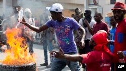 FILE - Demonstrators set barricade on fire during a violent protest in Port-au-Prince, Haiti, Nov. 23, 2018. Thousands of demonstrators clashed with police in Haiti's capital, demanding the ouster of President Jovenel Moise. 