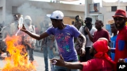FILE - Demonstrators set barricade on fire during a protest in Port-au-Prince, Haiti, Nov. 23, 2018. Thousands of demonstrators clashed with police in Haiti's capital, demanding the ouster of President Jovenel Moise. 
