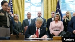 U.S. President Donald Trump signs the Trafficking Victims Protection Reauthorization Act in the Oval Office of the White House in Washington, Jan. 9, 2019.