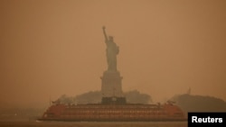 FILE PHOTO: The Statue of Liberty is covered in haze and smoke caused by wildfires in Canada, in New York, U.S., June 6, 2023. REUTERS/Amr Alfiky/File Photo