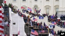 FILE - Trump supporters riot outside the U.S. Capitol, in Washingon, Jan. 6, 2021.