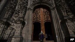 A woman wearing a face mask amid the spread of the new COVID-19 leaves the Cathedral in Mexico City, July 20, 2020. 