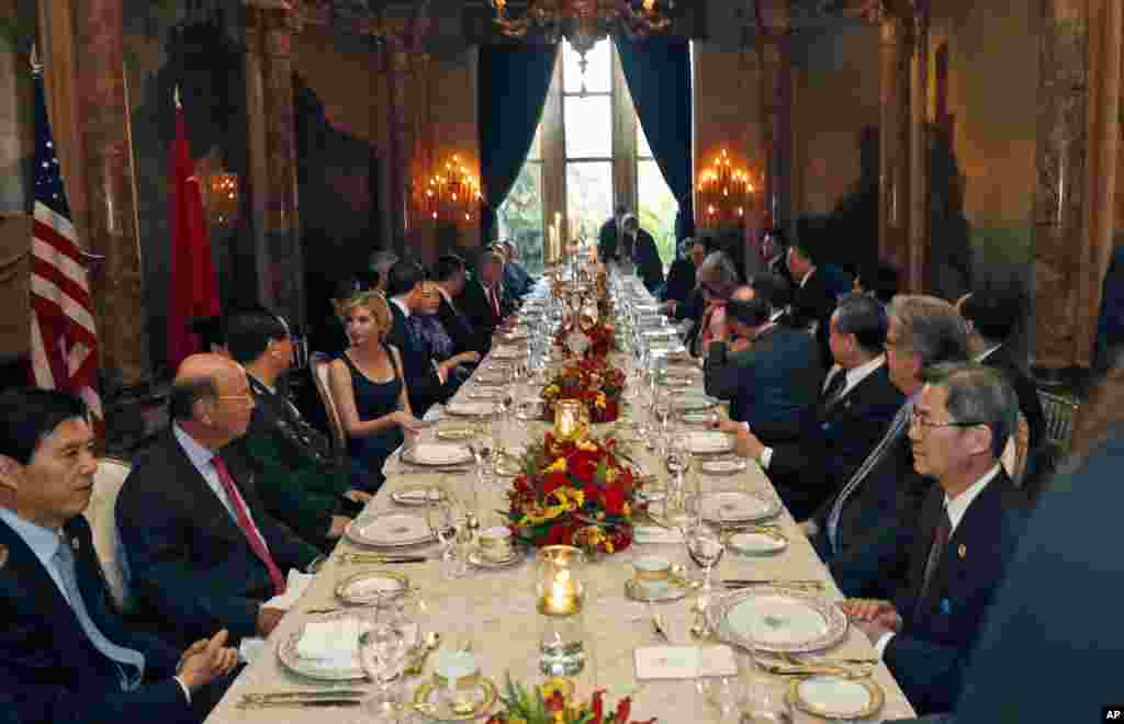 美国总统川普和家人、高级顾问同中国国家主席习近平和随行人员在佛罗里达州海湖庄园的晚宴上(2017年4月6日)。从图片上看，两位元首在交谈，库什纳和彭丽媛在交谈，伊万卡和房峰辉在交谈，而王毅和班农在注视两位元首。
