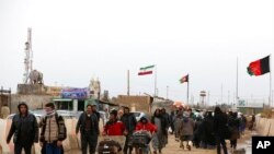 Tampak para warga Afghanistan kembali masuk ke negaranya melalui wilayah perbatasan antara negara tersebut dengan Iran di Provinsi Herat, di sebelah barat Afghanistan, pada 20 Februari 2019. (Foto: AP/Rahmat Gul) 