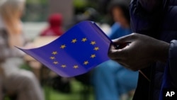 Seorang pria memegang bendera Uni Eropa saat berjalan di luar gedung Komisi Eropa selama perayaan Hari Eropa di Brussels pada 4 Mei 2024. (Foto: AP)