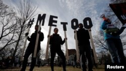 Para perempuan membawa tulisan bertuliskan "#MeToo" pada Women's March di Cambridge, 20 Januari 2018. 