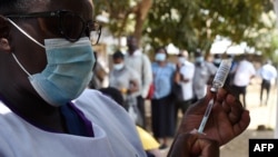 A Kenyan medic prepares a dose of the AstraZeneca Covid-19 vaccine, during a mass vaccination drive at the Dandora Health Center in Nairobi on Aug. 10, 2021.