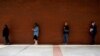 FILE - People who lost their jobs wait in line to file for unemployment benefits, following an outbreak of the coronavirus disease (COVID-19), at Arkansas Workforce Center in Fort Smith, Arkansas, April 6, 2020.