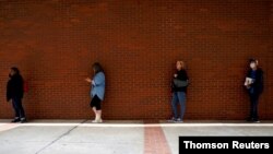 FILE - People who lost their jobs wait in line to file for unemployment benefits, following an outbreak of the coronavirus disease (COVID-19), at Arkansas Workforce Center in Fort Smith, Arkansas, April 6, 2020.