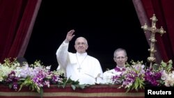 FILE - Pope Francis waves as he delivers a "Urbi et Orbi" message from the balcony overlooking St. Peter's Square at the Vatican, April 5, 2015. 