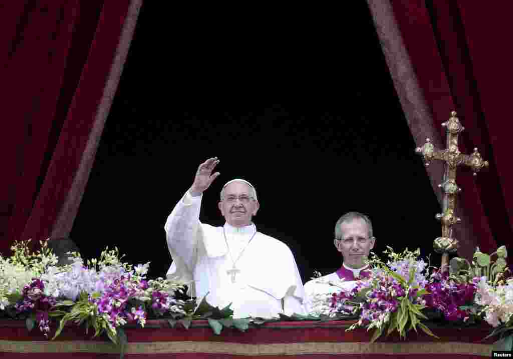 Pope Francis waves as he delivers a &quot;Urbi et Orbi&quot; message from the balcony overlooking St. Peter&#39;s Square at the Vatican, April 5, 2015.