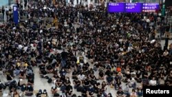 27일 홍콩 공항 입국장에서 시위대들이 '범죄인 인도 조례' 개정 철폐와 행정장관 사퇴를 요구하고 있다. 