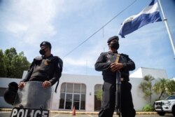 Nicaraguan police stand watch during a raid at La Prensa, the only national newspaper, after President Daniel Ortega's government opened customs fraud and money laundering investigations against the publication, in Managua, Aug. 13, 2021.