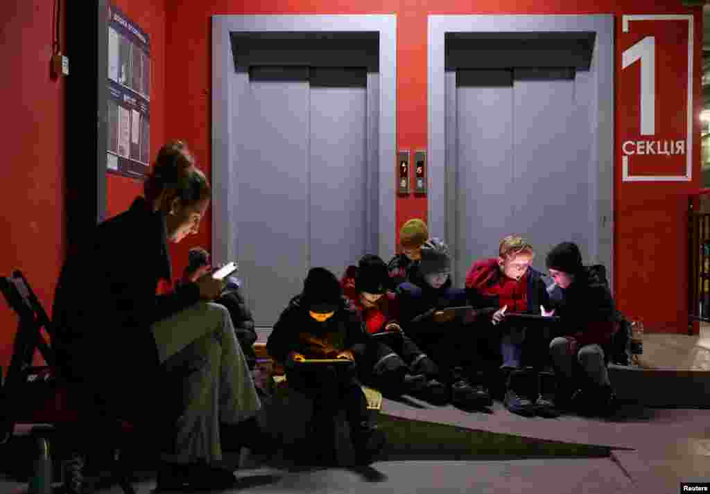 People take shelter inside an underground parking of an apartment building during a massive Russian missile attack across a country, in Lviv, Ukraine.