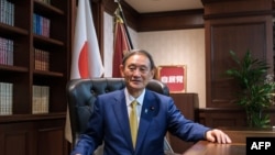 រូបឯកសារ៖ នាយករដ្ឋមន្ត្រី​ថ្មី​នៃ​ប្រទេស​ជប៉ុន​លោក Yoshihide Suga បាន​ថតរូប​នៅ​ការិយាល័យ​របស់​លោក​បន្ទាប់ពី​ធ្វើ​សន្និសីទ​កាសែត​នៅ​ទីស្នាក់ការ​គណបក្ស​នៅ​ទីក្រុង​តូក្យូ​នៅ​ថ្ងៃទី១៤ ខែកញ្ញា ឆ្នាំ២០២០។ 